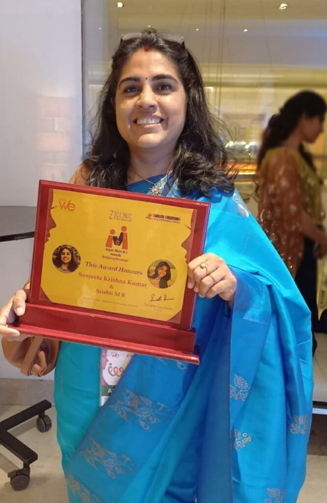 Sanjeeta KK holding Entrepreneur Mom & I award from Twilight Creations